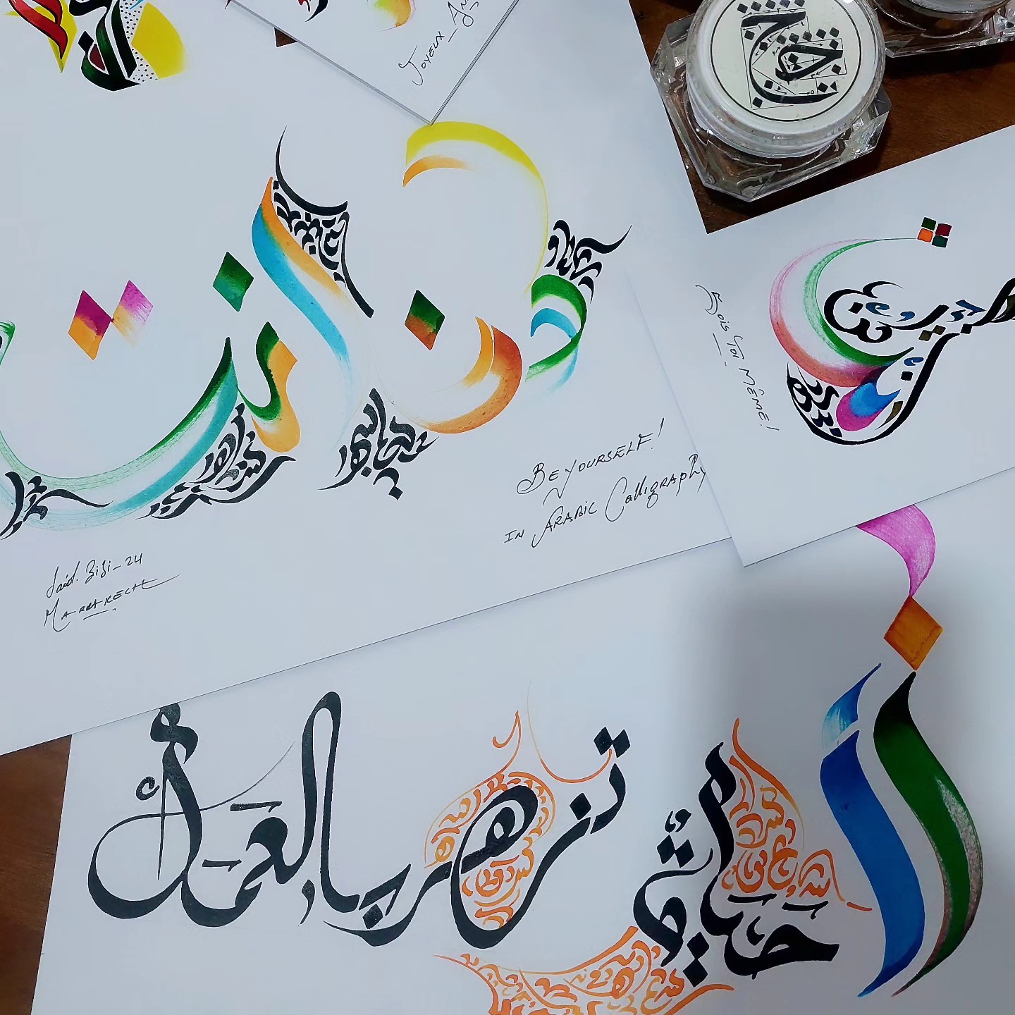 multiple pages with colorful arabic calligraphy letters and drawings