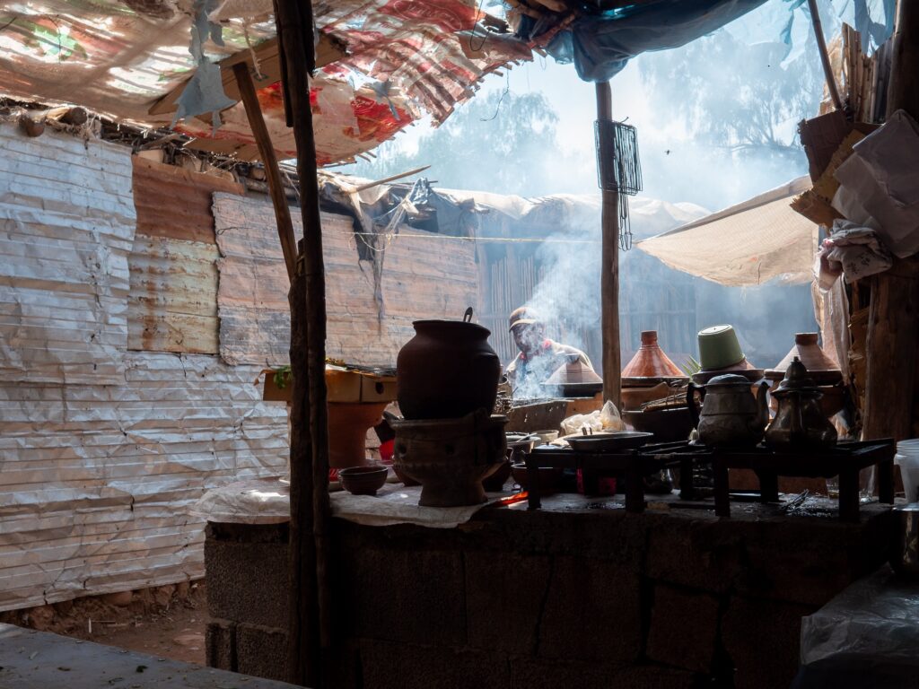 berber authentic real souk with someone cooking. smoke coming out of various pots