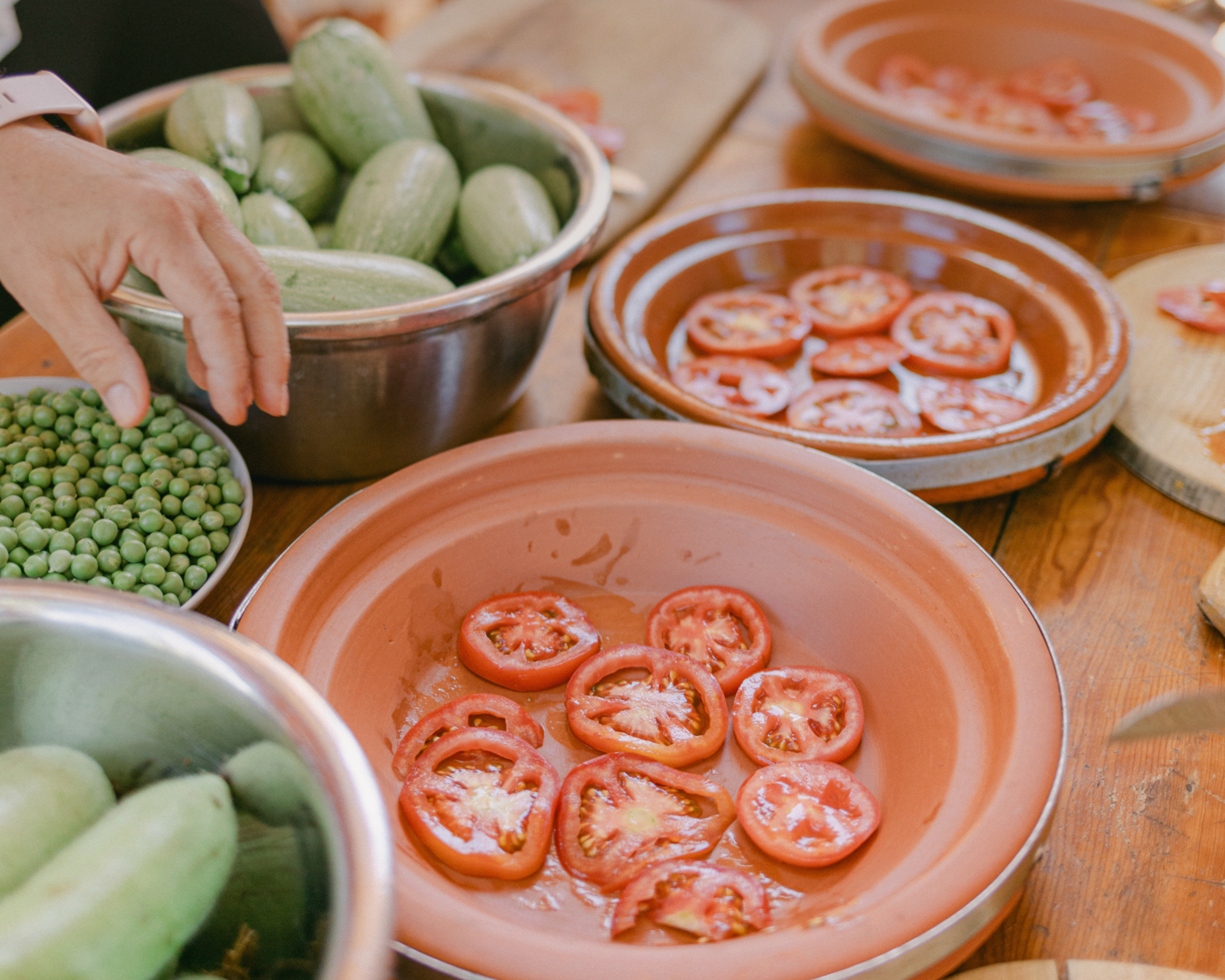 freshly cut tomatos, peas and zucchini on clay pots