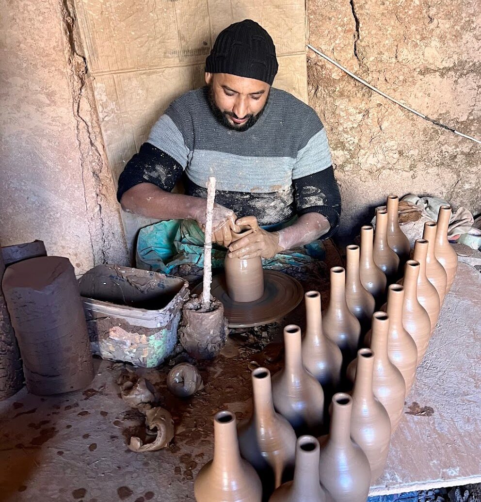 man in grey doing pottery