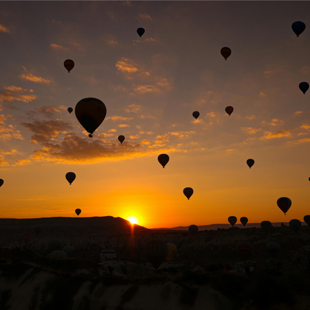 hot air balloons at a distance against the sunrise