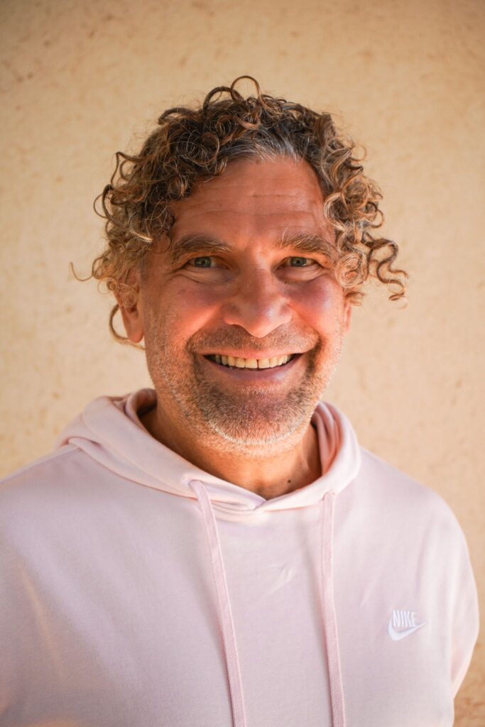 man smiling with curly grey hair