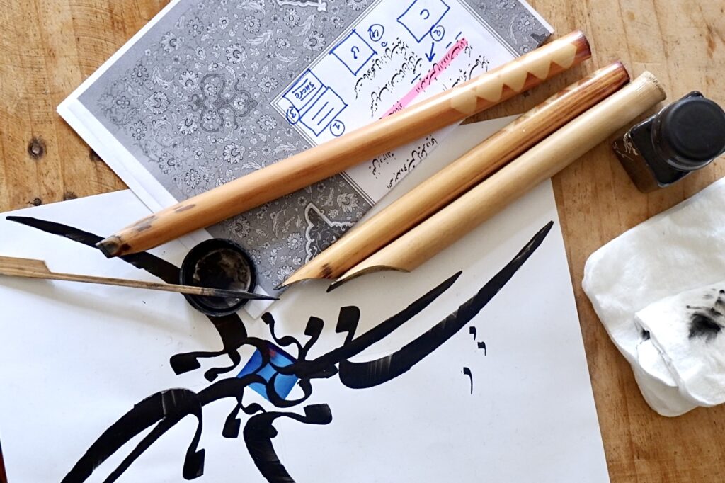 paper, wooden pens, and ink to write in arabic calligraphy