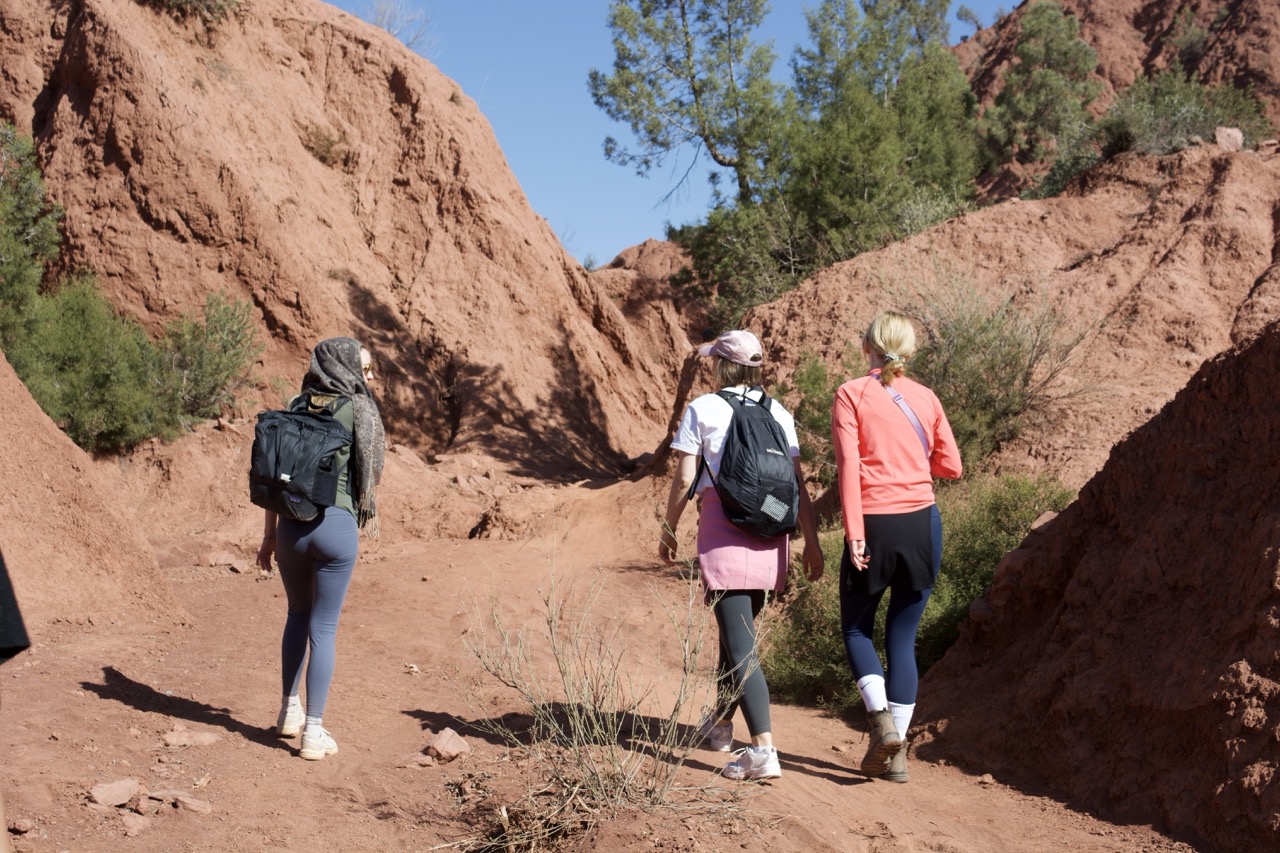 woman during the day walking in red coloured terrain